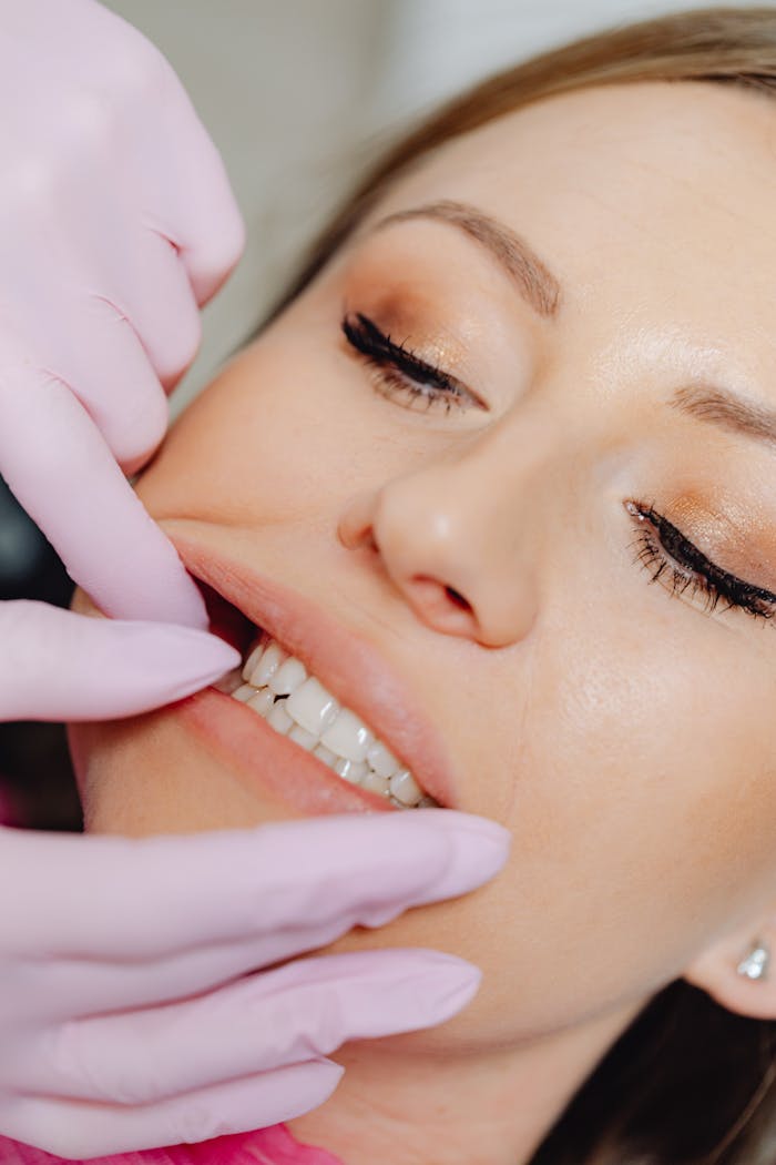 Detailed close-up of a dental examination showing a womans teeth with latex gloves.
